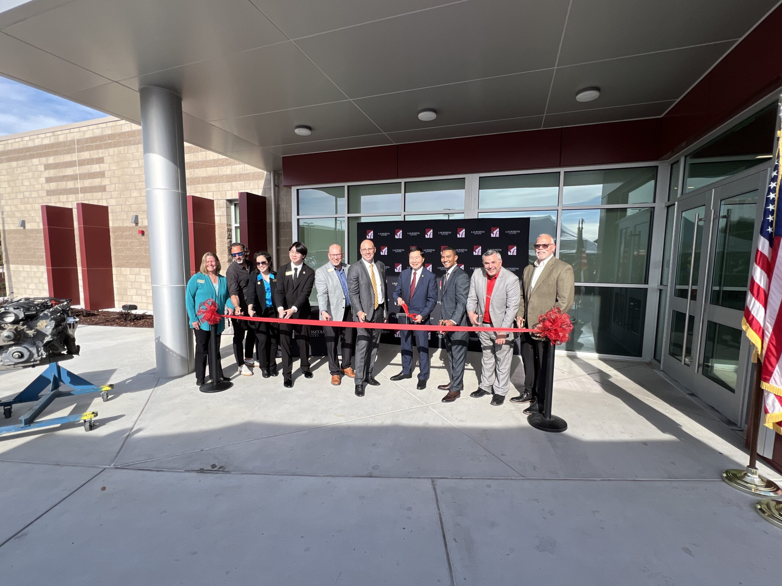 Picture of a member and group of people cutting a ribbon